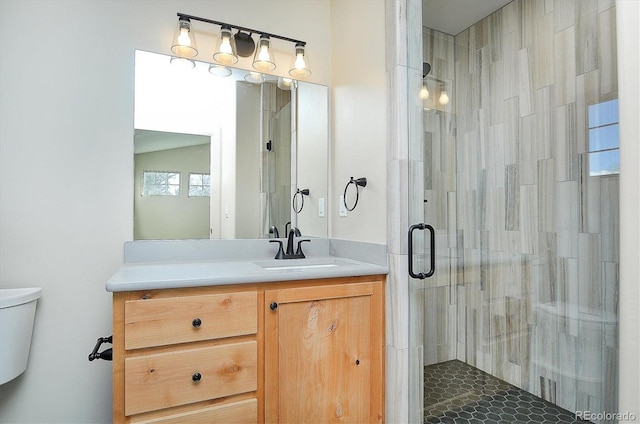 bathroom with an enclosed shower, vanity, and toilet