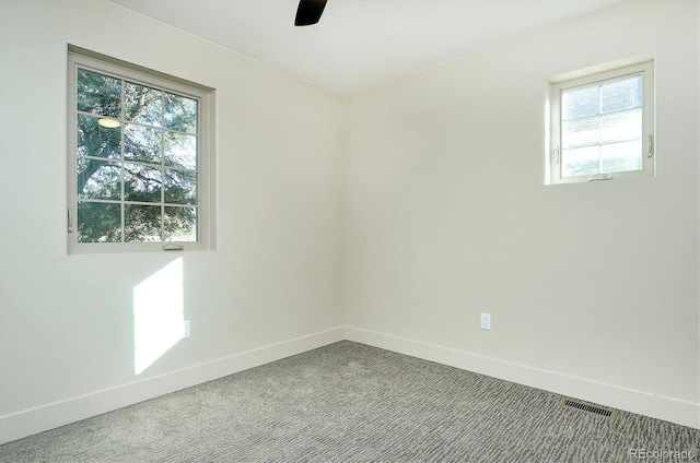 empty room with ceiling fan, carpet floors, and a healthy amount of sunlight