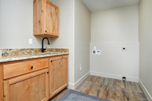 laundry area with cabinets, hookup for an electric dryer, sink, light hardwood / wood-style flooring, and hookup for a washing machine