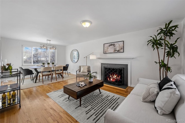 living room featuring light hardwood / wood-style flooring and a brick fireplace