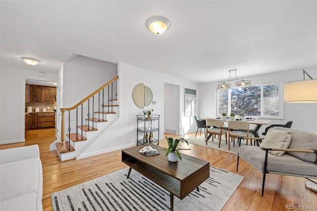 living room featuring light hardwood / wood-style flooring and a notable chandelier