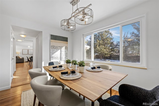 dining space with a chandelier and light wood-type flooring