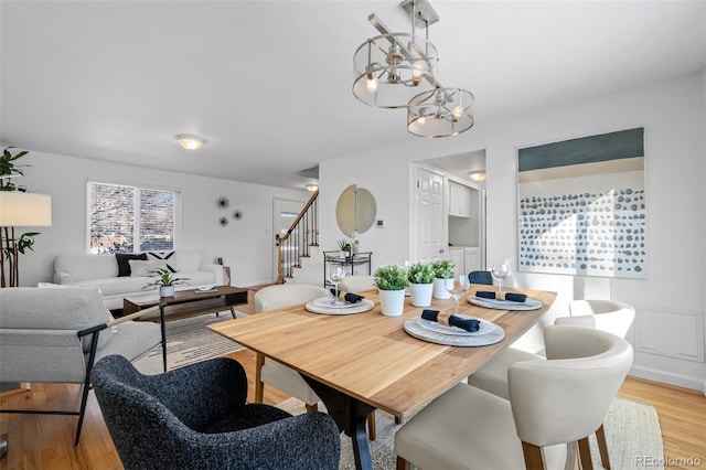 dining area featuring a notable chandelier and light wood-type flooring