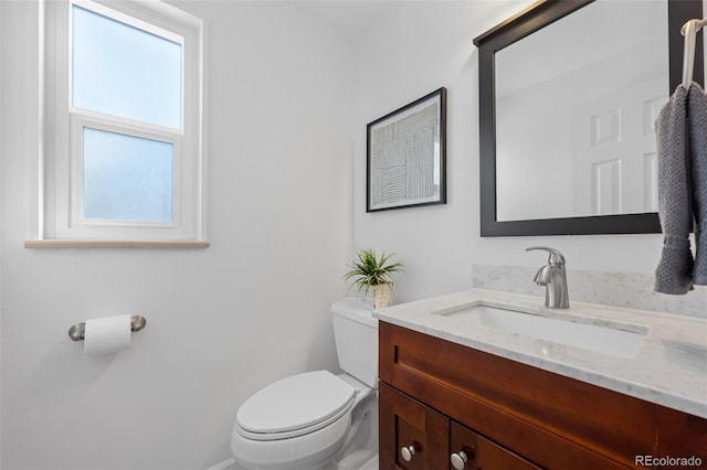 bathroom featuring plenty of natural light, vanity, and toilet