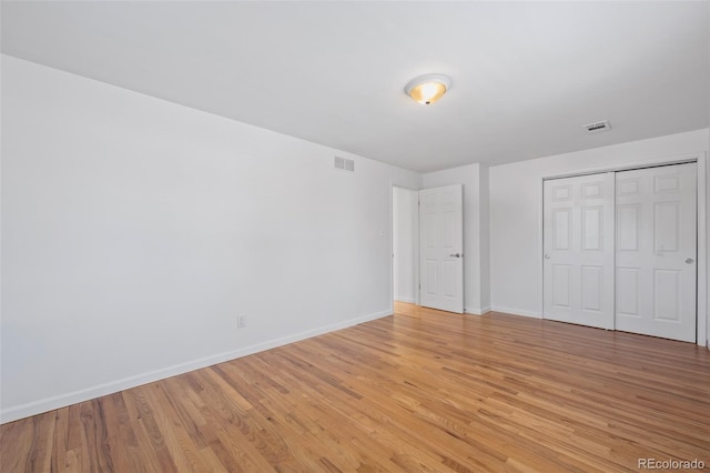 unfurnished bedroom with a closet and light wood-type flooring