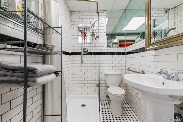 1301 N Ogden St Unit 1A, Denver, CO 80218 - full bathroom featuring a stall shower, tile patterned flooring, and tile walls