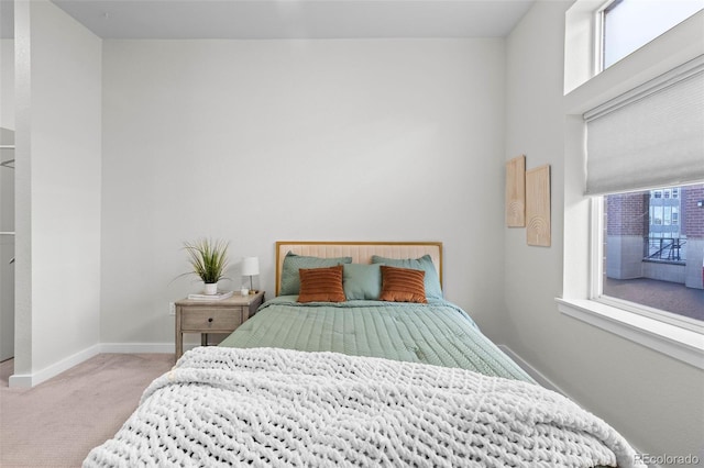 carpeted bedroom featuring multiple windows and baseboards