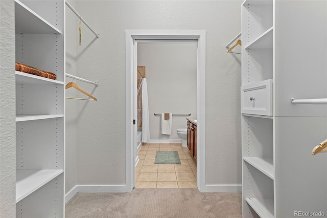 spacious closet featuring light carpet and light tile patterned floors