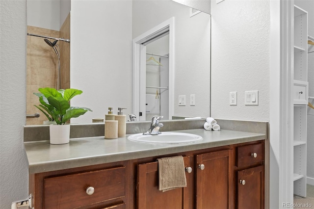 bathroom with a textured wall and vanity
