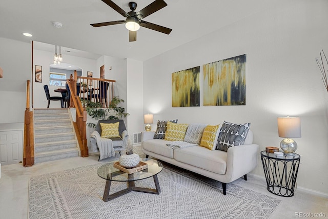 living room with carpet flooring, visible vents, a ceiling fan, baseboards, and stairway