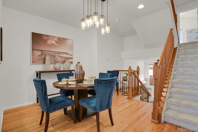 dining area with recessed lighting, baseboards, light wood finished floors, and an inviting chandelier