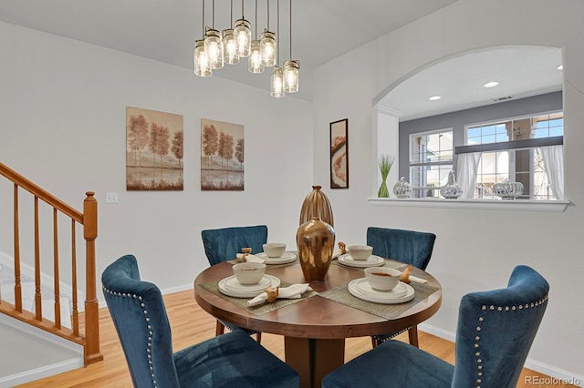 dining area featuring stairway, wood finished floors, visible vents, and baseboards