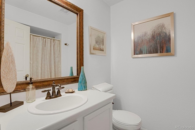 full bath featuring toilet, vanity, and visible vents