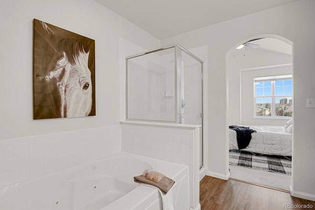 ensuite bathroom with ensuite bathroom, ceiling fan, wood finished floors, a jetted tub, and a shower stall