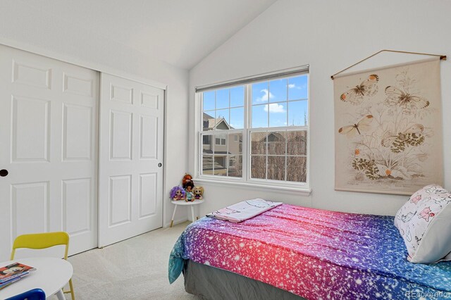 carpeted bedroom with lofted ceiling and a closet