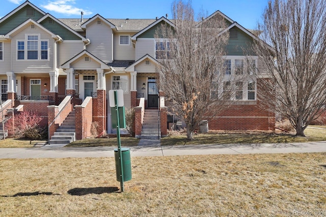 view of front of property featuring a front yard and brick siding