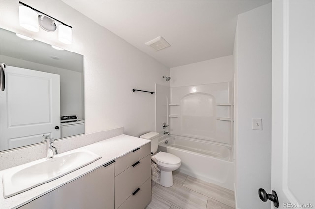 full bathroom featuring vanity, toilet, bathing tub / shower combination, and washer / clothes dryer