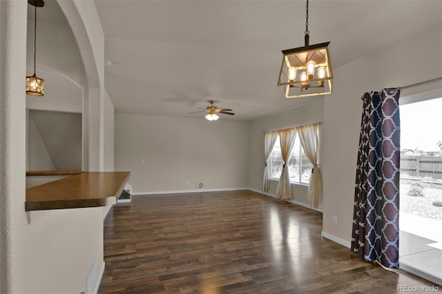 9455 Shinnecock Ct, Peyton, CO 80831 - unfurnished living room featuring a chandelier, dark wood-style floors, ceiling fan, and baseboards