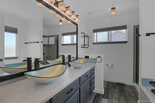 9455 Shinnecock Ct, Peyton, CO 80831 - bathroom featuring double vanity, a shower stall, wood finished floors, and a bath