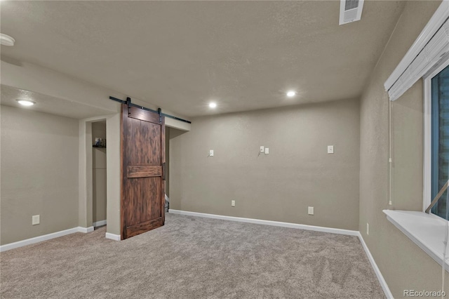 9455 Shinnecock Ct, Peyton, CO 80831 - finished below grade area with a barn door, carpet flooring, baseboards, a textured ceiling, and recessed lighting