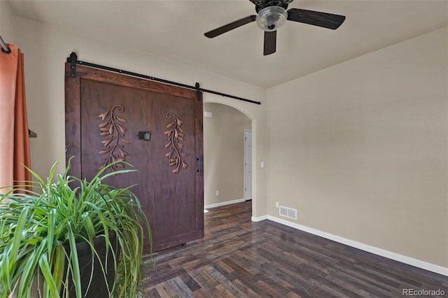9455 Shinnecock Ct, Peyton, CO 80831 - spare room featuring a barn door, arched walkways, a ceiling fan, and baseboards