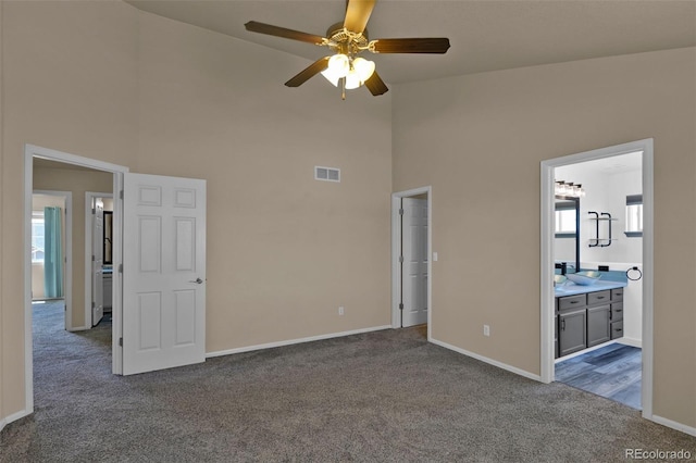 9455 Shinnecock Ct, Peyton, CO 80831 - unfurnished bedroom with dark colored carpet, high vaulted ceiling, baseboards, connected bathroom, and a ceiling fan