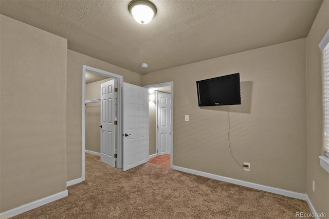 9455 Shinnecock Ct, Peyton, CO 80831 - unfurnished bedroom featuring carpet flooring, a textured ceiling, baseboards, a walk in closet, and a closet