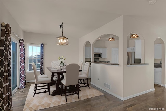 9455 Shinnecock Ct, Peyton, CO 80831 - dining room with arched walkways, wood finished floors, baseboards, and vaulted ceiling