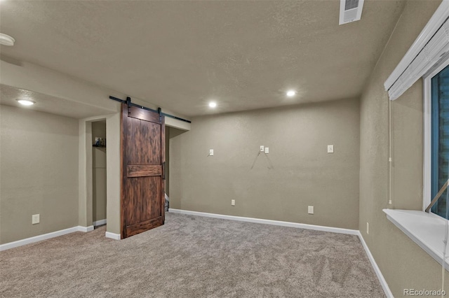 9455 Shinnecock Ct, Peyton, CO 80831 - finished below grade area with a barn door, carpet flooring, a textured ceiling, baseboards, and recessed lighting