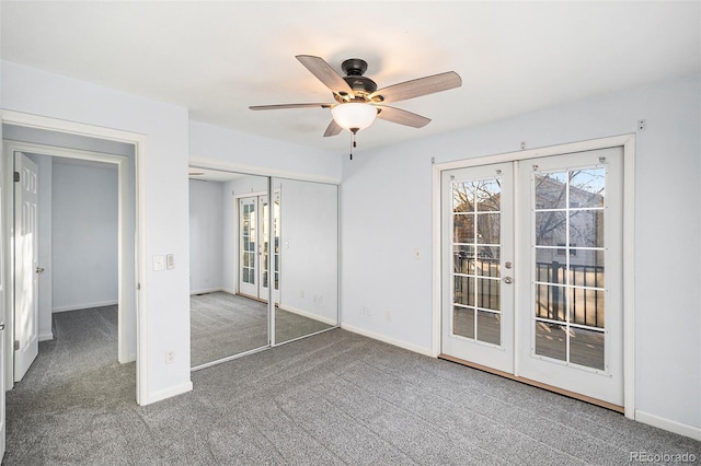 carpeted spare room featuring a healthy amount of sunlight, ceiling fan, and french doors