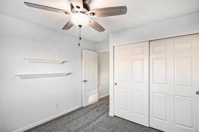 unfurnished bedroom with dark colored carpet, ceiling fan, and a closet