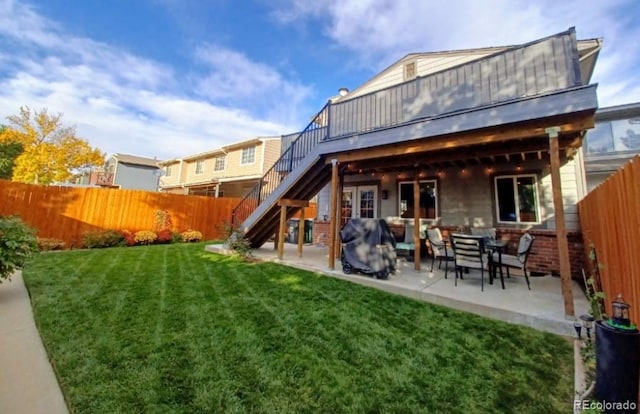 back of house featuring a patio and a lawn