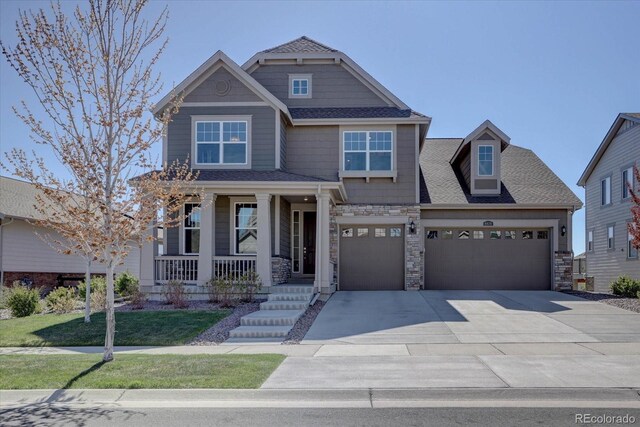 craftsman inspired home with a porch, a garage, and a front yard