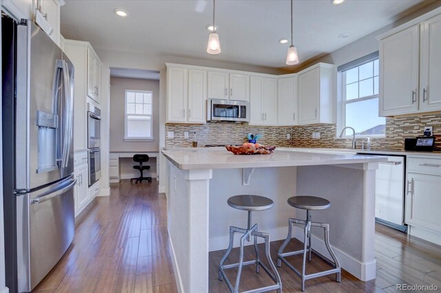 kitchen with stainless steel appliances, white cabinets, and a kitchen island