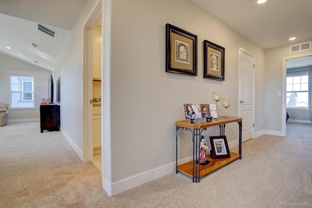 corridor featuring light carpet and lofted ceiling