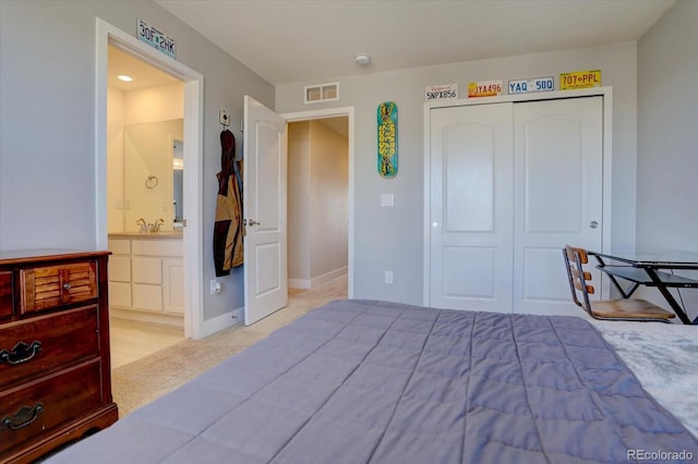 carpeted bedroom featuring connected bathroom, sink, and a closet