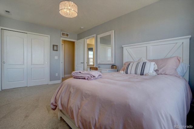 carpeted bedroom featuring a chandelier and a closet