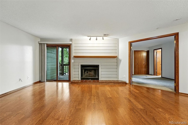 2960 Shadow Creek Dr Unit 201, Boulder, CO 80303 - unfurnished living room with a textured ceiling, wood finished floors, and a fireplace