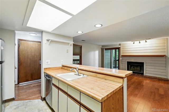 2960 Shadow Creek Dr Unit 201, Boulder, CO 80303 - kitchen with a peninsula, dishwasher, a large fireplace, light wood-style flooring, and open shelves