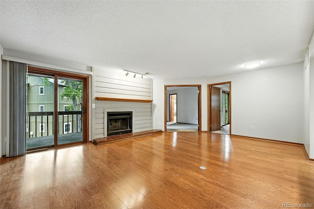 2960 Shadow Creek Dr Unit 201, Boulder, CO 80303 - unfurnished living room with a textured ceiling, wood finished floors, and a large fireplace