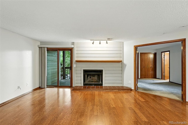 2960 Shadow Creek Dr Unit 201, Boulder, CO 80303 - unfurnished living room with wood finished floors, a textured ceiling, a fireplace, and track lighting
