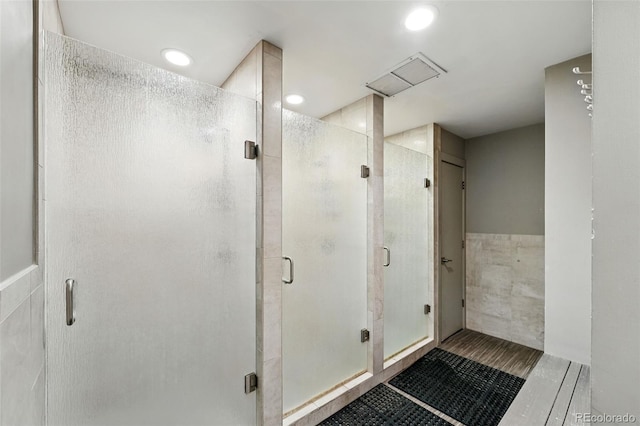 2960 Shadow Creek Dr Unit 201, Boulder, CO 80303 - bathroom featuring tile walls, a shower stall, recessed lighting, and wainscoting
