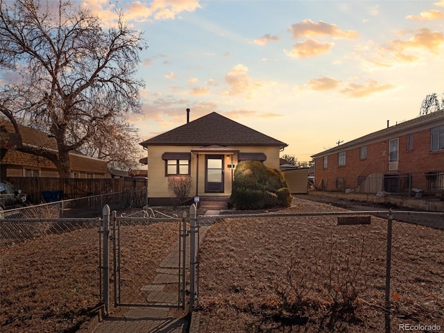 view of front of house featuring a fenced front yard, entry steps, a gate, and a shingled roof