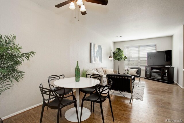 dining area with wood-type flooring and ceiling fan