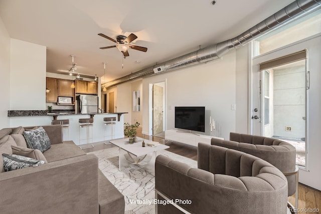 living room with light wood-type flooring, ceiling fan, and track lighting