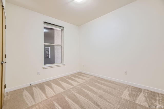 carpeted spare room with baseboards