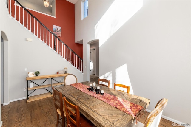 dining area with a high ceiling and dark hardwood / wood-style floors