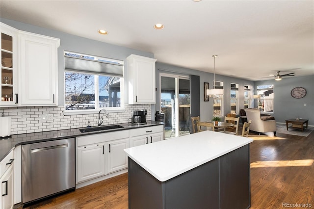 kitchen with dishwasher, a kitchen island, sink, white cabinetry, and hanging light fixtures