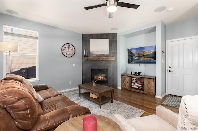 living room with ceiling fan, a fireplace, and hardwood / wood-style flooring