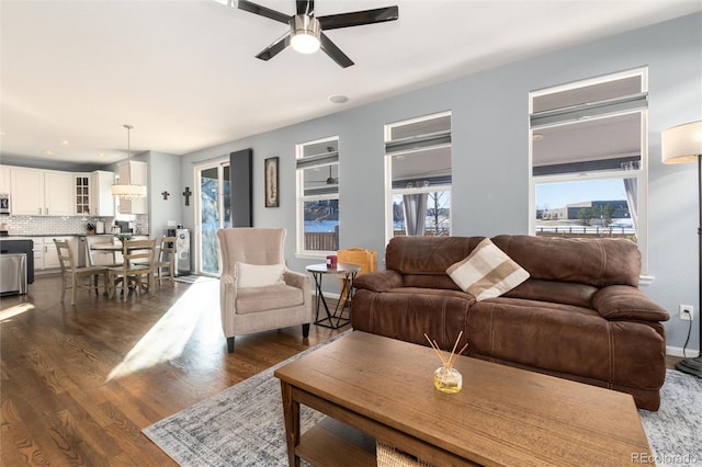 living room featuring ceiling fan and dark hardwood / wood-style floors